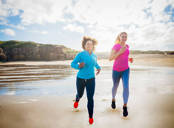 istock Women Running along a Beach Together 621834394