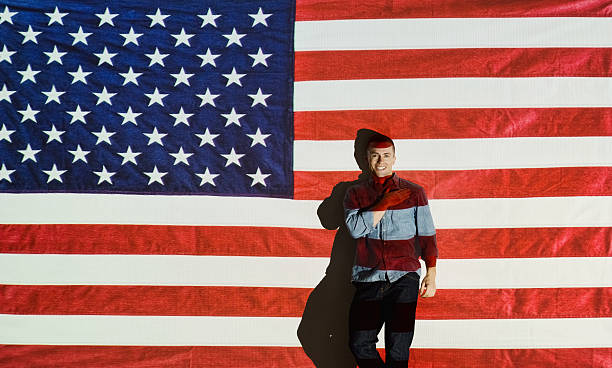 istock Smiling man hand on heart in front of flag 621834586