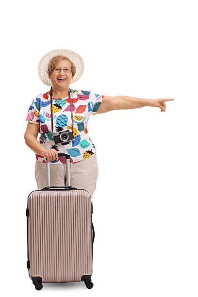 istock Mature tourist with a suitcase pointing right 621836086