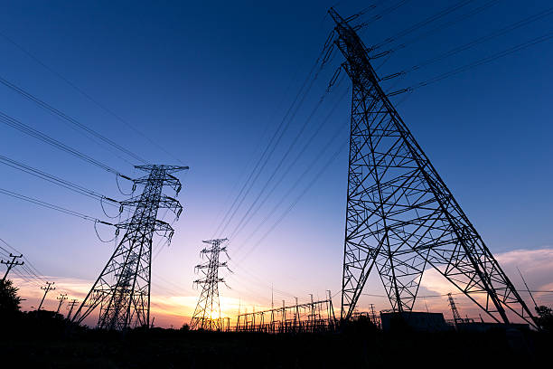 istock High-voltage power transmission towers in sunset sky background 621836420