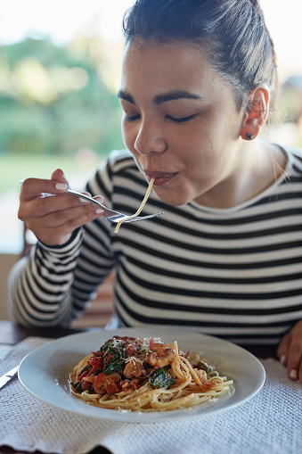 Portrait of an attractive young woman eating pasta