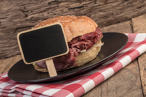 istock Roast beef burger and a chalkboard on wooden table 621837538