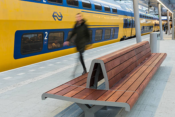 Utrecht, The Netherlands - October 12, 2016: NS Central Railway Station Utrecht with walking people at the platform with train and bench, The Netherlands.