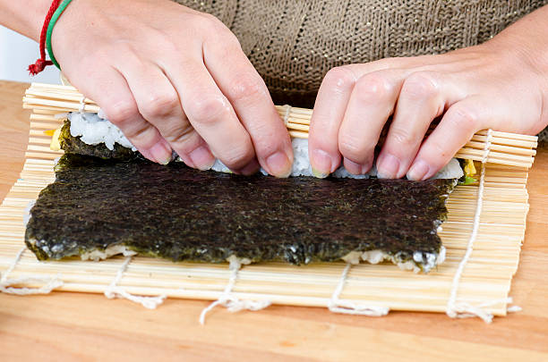 istock Woman making california roll, 621837898