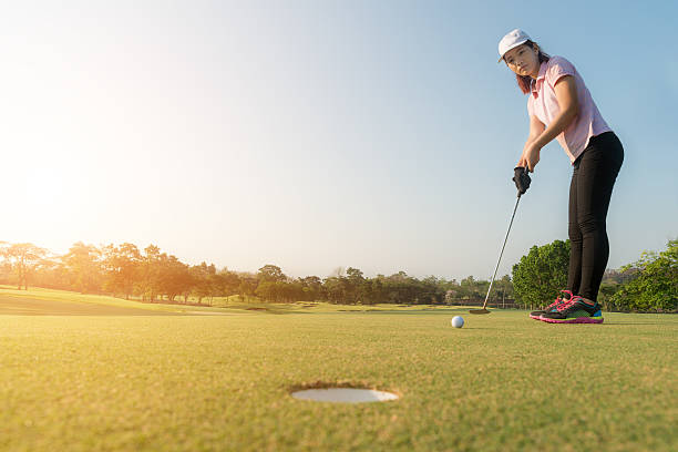 istock Asian woman golf player putting golf ball on green. 621838008