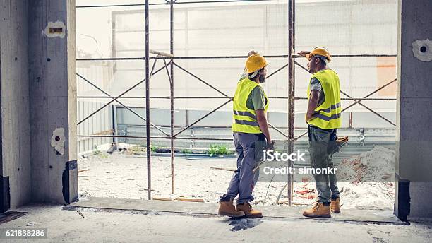 Construction Workers Discussing Stock Photo - Download Image Now - Construction Worker, Construction Site, Discussion