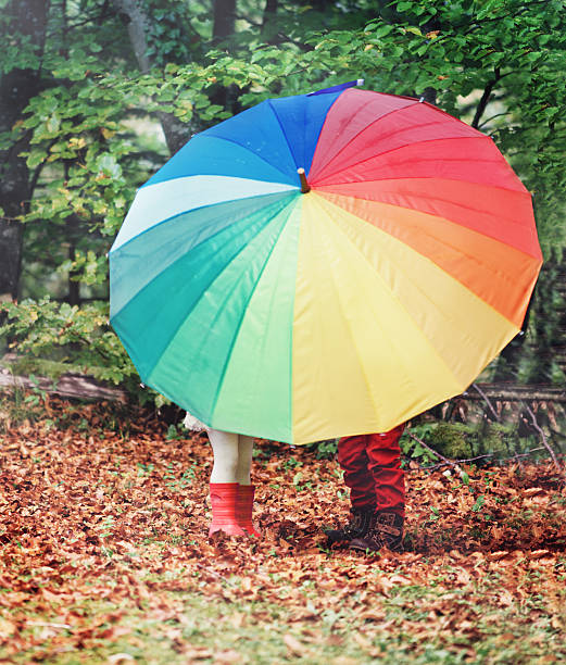 istock Little Girl and Boy under Umbrella 621839708