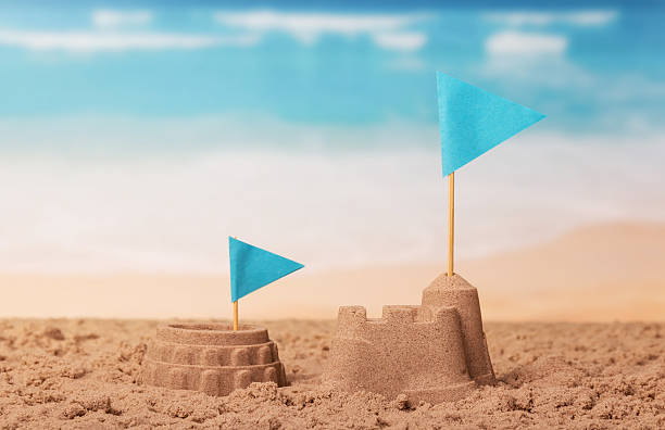 istock Coliseum and sand castle, flags on background of coast. 621840042
