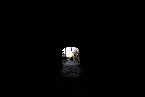 People silhouette in dark tunnel