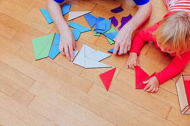 istock teacher and child playing with geometric shapes, early learning 621842898