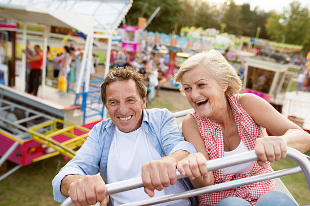 casal de idosos em um passeio em parque de diversões - couple senior adult travel action - fotografias e filmes do acervo