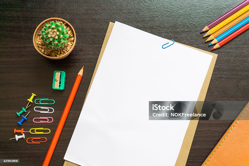 Blank white paper and colored pencil on the desk. Top - Garment Stock Photo