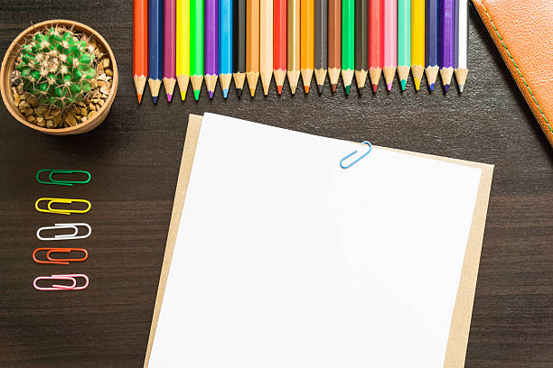 istock Blank white paper and colored pencil on the desk. 621843926