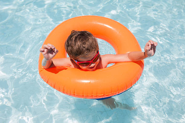 istock Above view of kid having fun in swimming pool. 621844634