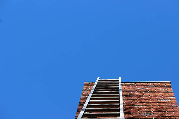 istock Ladder Leaned on Brick Chimney with Blue Sky Background 621847362