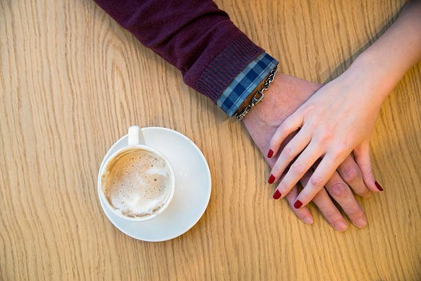 istock Coffee cup and holding hands at the wooden table 621847506