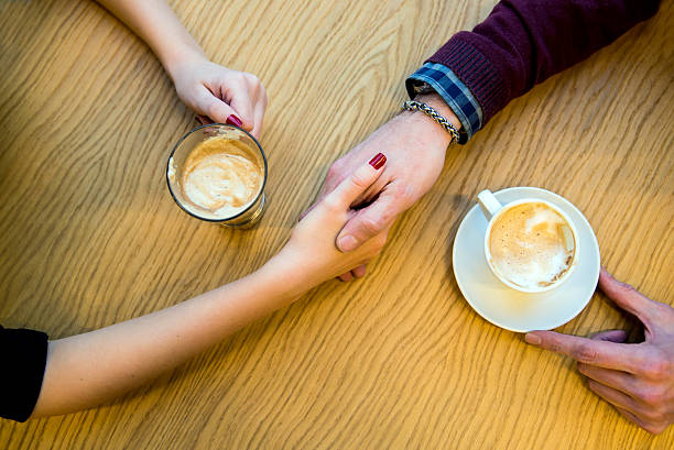istock couple in love holding hands in a cafe 621847852