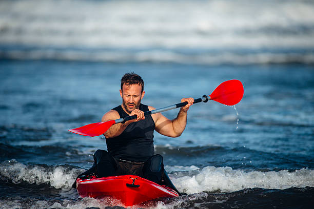 man kayaking in the sea - ankle deep in water imagens e fotografias de stock