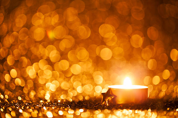 zapalona świeca na rozmytych światłach - tło christmas tea light - tea light votive candle candle candlelight zdjęcia i obrazy z banku zdjęć