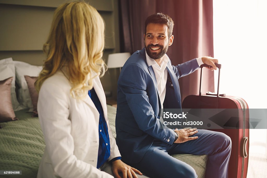 Business couple in formal wear traveling Business couple in formal wear in hotel room Adult Stock Photo