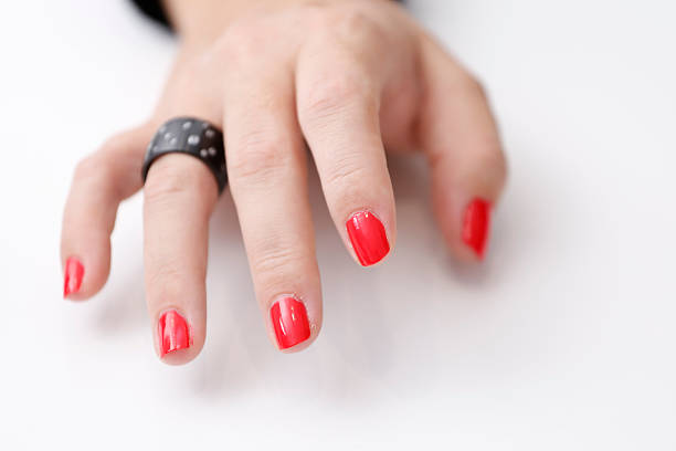 White woman right hand with red painted nails isolated on a white background