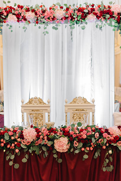 istock Rich dinner table decorated with red flower festoon 621860328