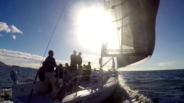 Sailing team on sailboat on sunny ocean
