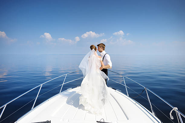 istock Happy bride and groom on a yacht 621893352