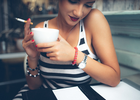 Beautiful young woman drinking coffee at cafe