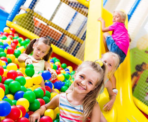 istock Girl playing with multicolored plastic balls 621894544