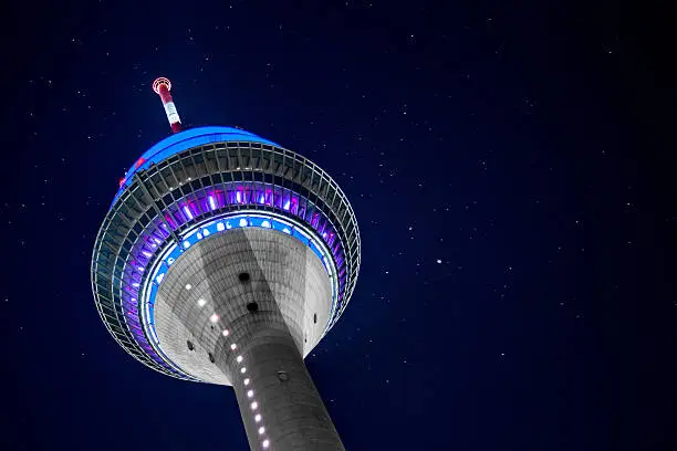 The Düsseldorf TV Tower illuminated at night. In the background you can see stars.