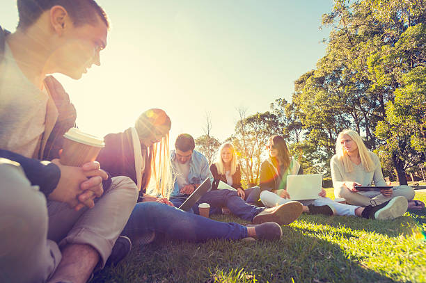 Group of young people using technology Group of young people using technology in the park multi ethnic group college student group of people global communications stock pictures, royalty-free photos & images