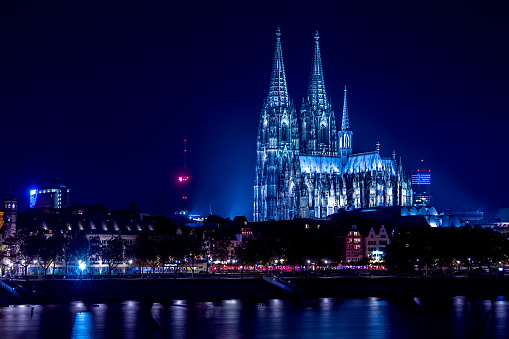 The illuminated Cologne Cathedral at night from the other side of the Rhine.
