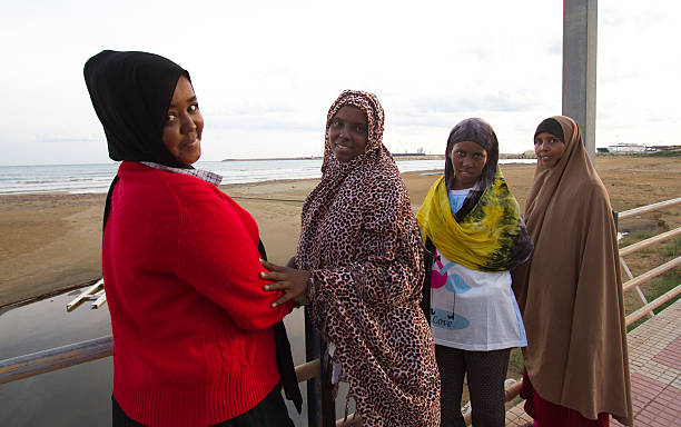 поццалло, сицилия: только что прибывшие сомалийские женщины-мигранты на пляже - somalian culture стоковые фото и изображения