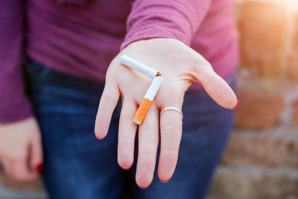 壊れたタバコを持つ開いた手のひら - smoking issues cigarette breaking broken ストックフォトと画像