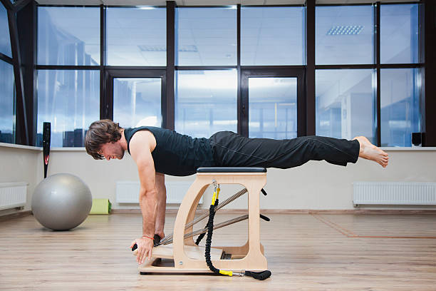 istock Man on pilates training equipment. Fit and slim. 621896998
