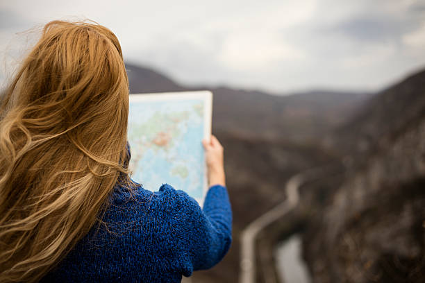 istock Woman on the hill holding atlas map. 621897234