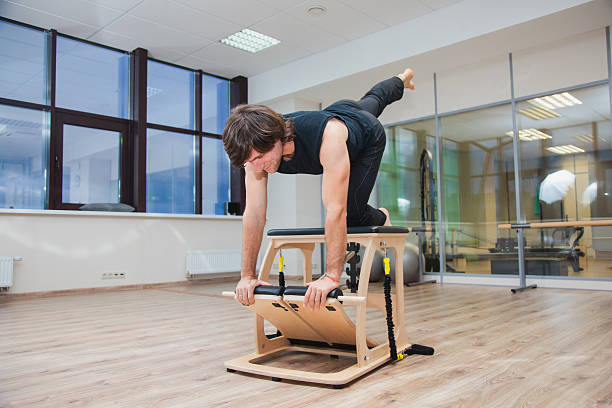 istock Man on pilates equipment. Daily workout 621898304