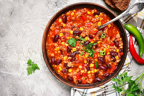 Chili con carne - traditional dish of mexican cuisine.Top view. Chili con carne in a clay bowl on a concrete or stone rustic background- traditional dish of mexican cuisine.Top view. chili con carne photos stock pictures, royalty-free photos & images