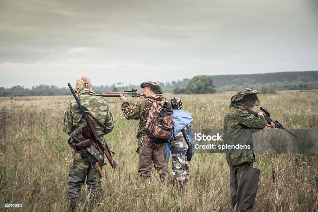 Hunters preparing for hunting in rural field in overcast day Hunters preparing for hunting in rural field in overcast day during hunting season Hunter Stock Photo