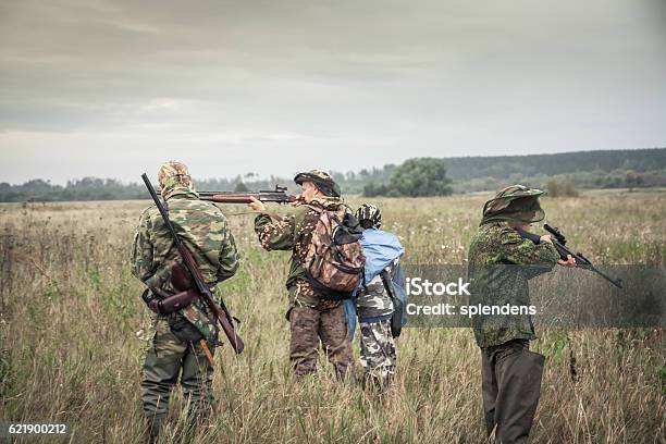 Hunters Preparing For Hunting In Rural Field In Overcast Day Stock Photo - Download Image Now