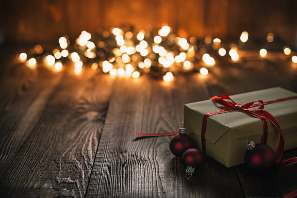 istock Christmas Ornaments and Gift on Wood Background and defocused lights 621904376