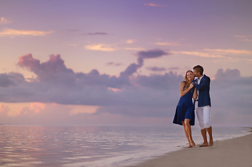 Beautiful romantic couple on a sunset on tropical beach