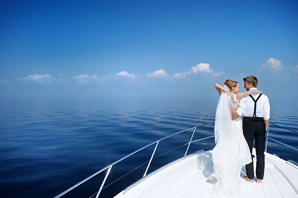 istock Happy bride and groom on a yacht 621905702