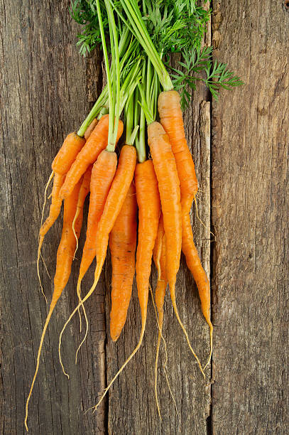 istock fresh carrots on wooden surface 621905854