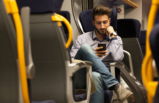 istock Young man looking at his smartphone in train 621906254