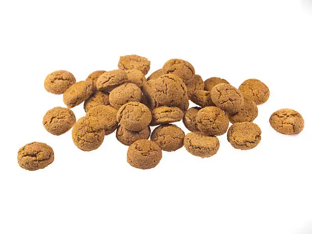 Bunch of Pepernoten cookies seen from side as Sinterklaas decoration on white background for dutch sinterklaasfeest holiday event on december 5th