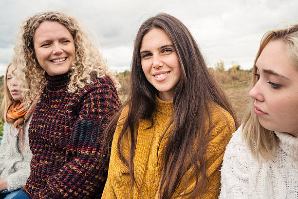 istock Mother and teenage daughters strolling in trailer in field. 621908270