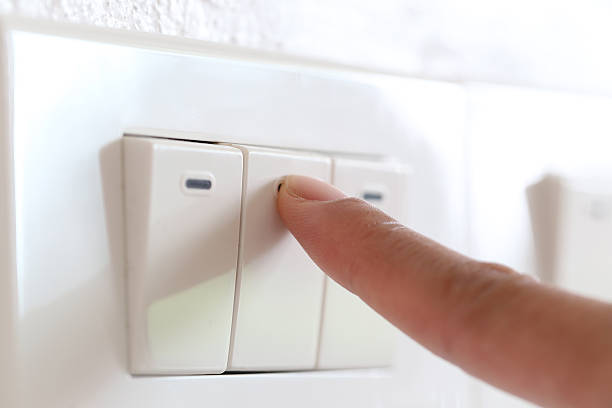 istock fingers are off light switch in the house. 621911748