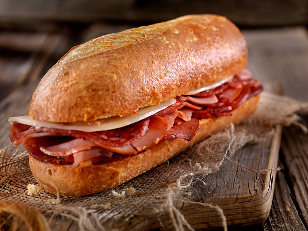 italienisches sandwich mit salami, genua, prosciutto und provolone - sandwich submarine sandwich ham bun stock-fotos und bilder